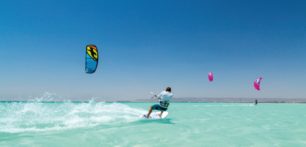 Rider on the turquoise lagoon with kites in the sky – kitesurfing lessons in Hurghada