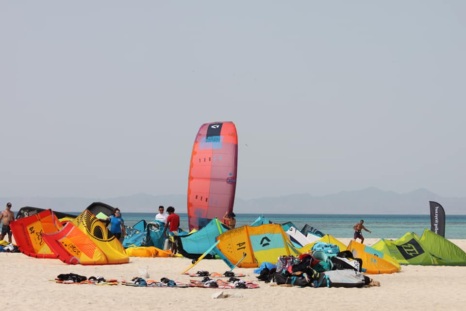 Kites and kiteboards laid out on a sandy island beach during a Red Sea kite safari